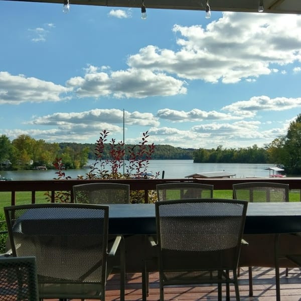 Outdoor dining area at Lighthouse Bistro with a scenic view of Atwood Lake and a cloudy sky.